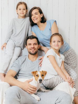friendly-family-pose-together-against-white-two-little-sisters-father-mother-their-pet