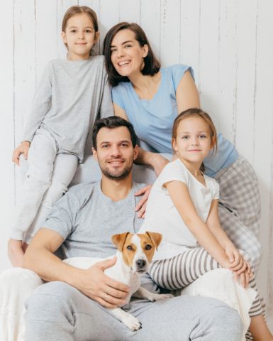 friendly-family-pose-together-against-white-two-little-sisters-father-mother-their-pet